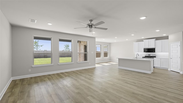 unfurnished living room with light wood-style floors, ceiling fan, visible vents, recessed lighting, and a sink