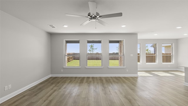 empty room with visible vents, baseboards, a ceiling fan, and wood finished floors