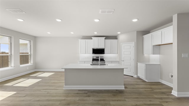 kitchen featuring recessed lighting, tasteful backsplash, visible vents, and white cabinetry
