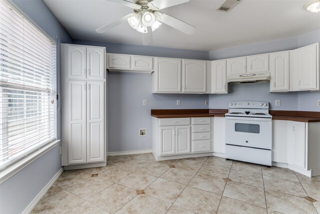 kitchen featuring electric range, ceiling fan, light tile patterned floors, white cabinets, and butcher block counters