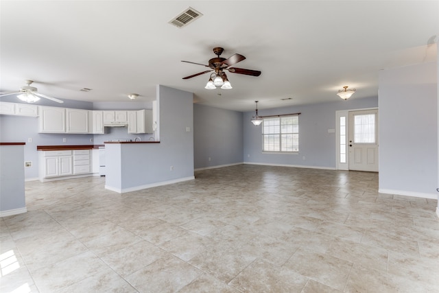 unfurnished living room with ceiling fan and light tile patterned floors