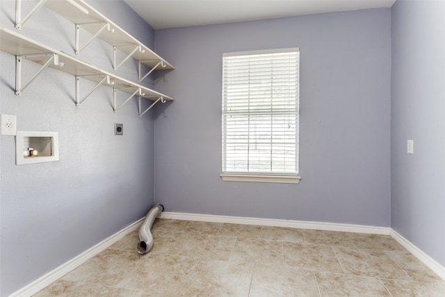 clothes washing area featuring hookup for a washing machine, light tile patterned flooring, hookup for an electric dryer, and a wealth of natural light