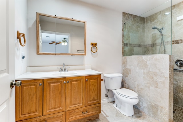 bathroom with ceiling fan, tiled shower, toilet, tile patterned floors, and vanity