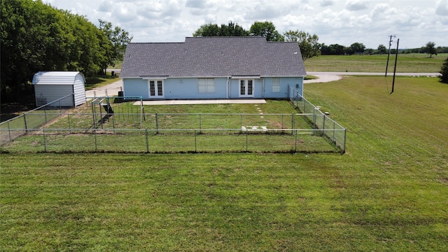 back of property featuring a storage unit and a yard