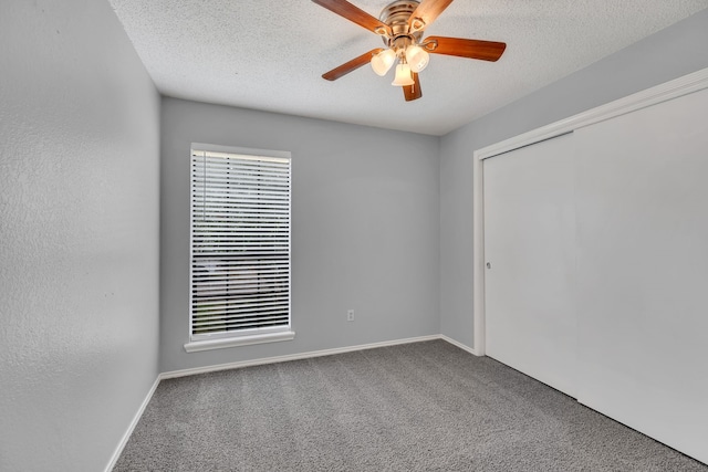 empty room with carpet floors, a textured ceiling, and ceiling fan