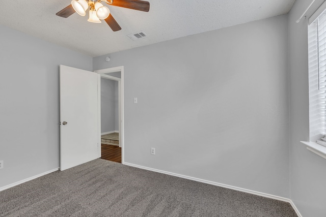 unfurnished room with a textured ceiling, carpet floors, and ceiling fan