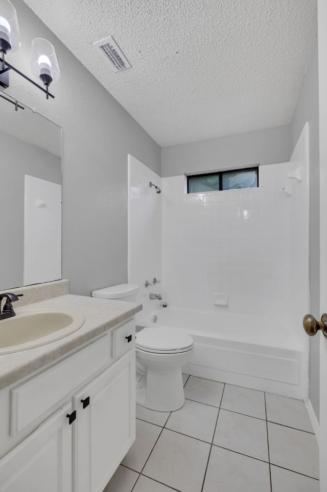 full bathroom with tiled shower / bath, a textured ceiling, tile patterned floors, toilet, and vanity