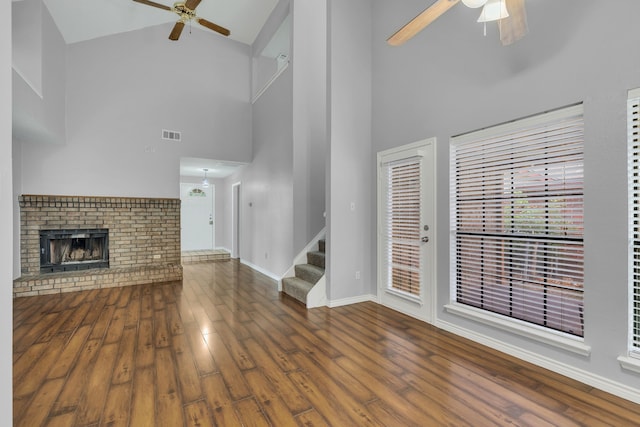 unfurnished living room featuring dark hardwood / wood-style floors, high vaulted ceiling, and ceiling fan