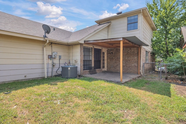 back of house with cooling unit, a patio, and a yard