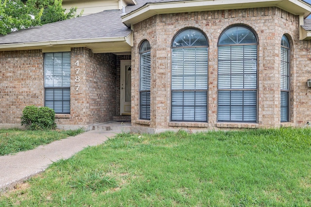 entrance to property featuring a lawn