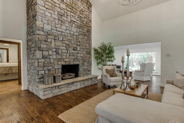 living room with a stone fireplace, dark hardwood / wood-style flooring, and high vaulted ceiling