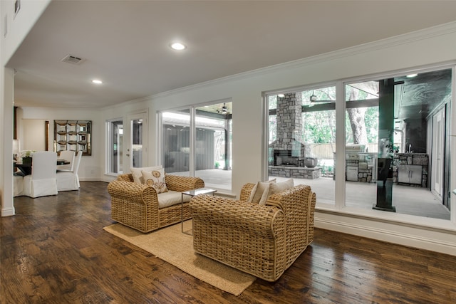 living room featuring dark hardwood / wood-style floors, ornamental molding, and plenty of natural light