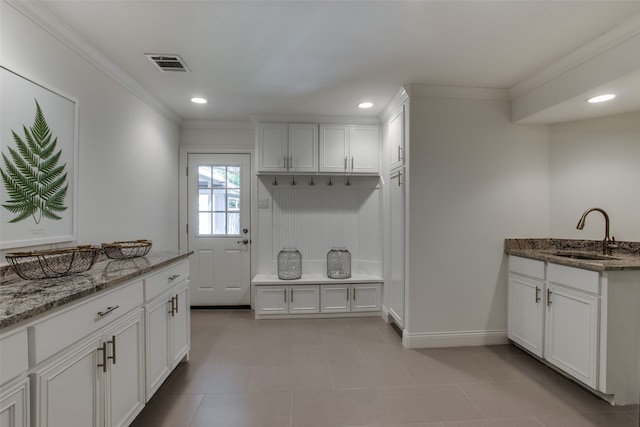 interior space with tile patterned flooring, crown molding, and sink