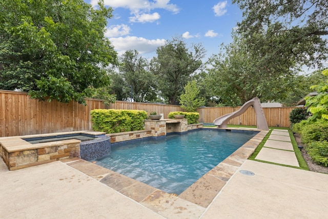 view of swimming pool featuring a water slide and an in ground hot tub