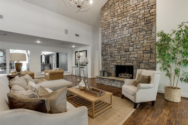 living room featuring a stone fireplace, wood-type flooring, high vaulted ceiling, and an inviting chandelier