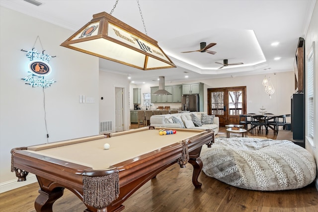 recreation room featuring a tray ceiling, french doors, light wood-type flooring, ceiling fan, and billiards