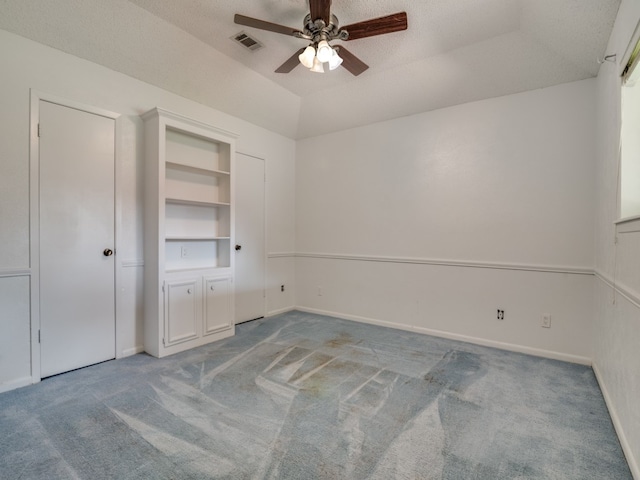 unfurnished bedroom with light carpet, a textured ceiling, and ceiling fan