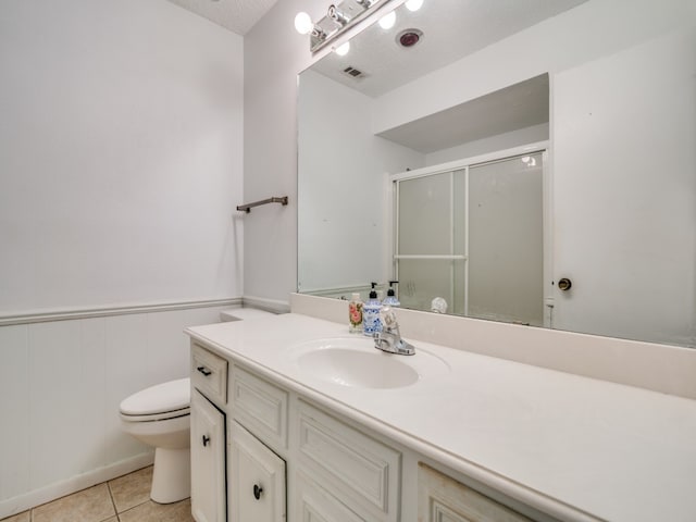 bathroom with tile patterned floors, vanity, a textured ceiling, and toilet