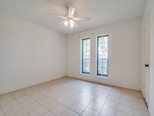 spare room featuring ceiling fan, a textured ceiling, and light tile patterned floors