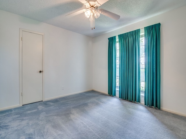 empty room featuring ceiling fan, a textured ceiling, and carpet floors