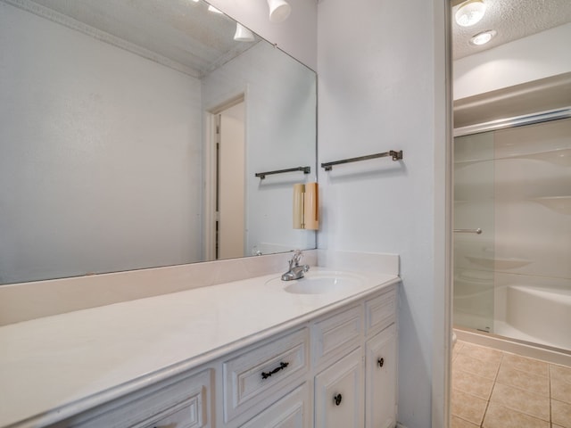 bathroom featuring vanity, a textured ceiling, a shower with door, and tile patterned flooring