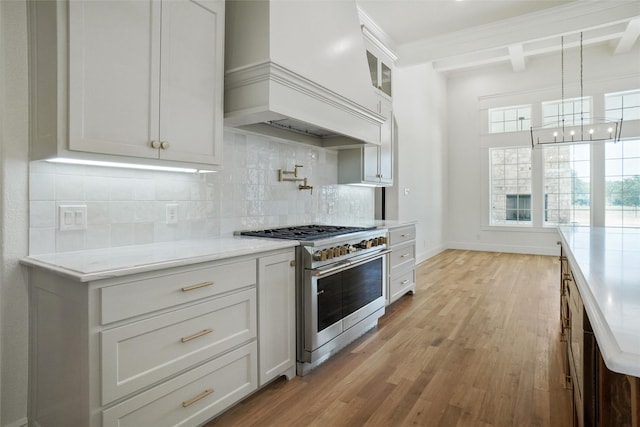 kitchen with custom range hood, white cabinetry, light hardwood / wood-style floors, double oven range, and beam ceiling