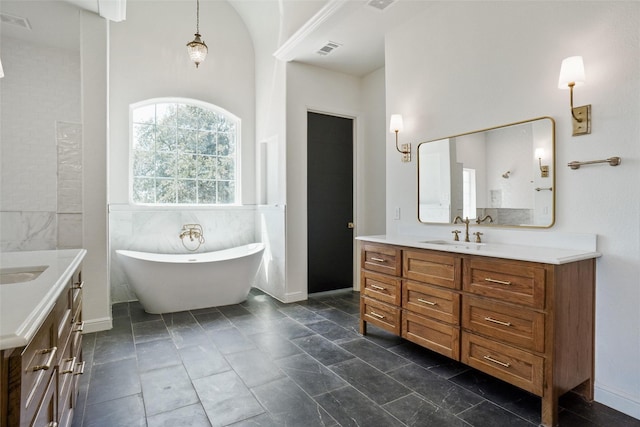 bathroom with vanity, a bathtub, and tile walls