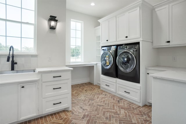 laundry room with cabinets, sink, washer and clothes dryer, and plenty of natural light