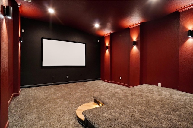 cinema room with ornamental molding, lofted ceiling, and carpet flooring