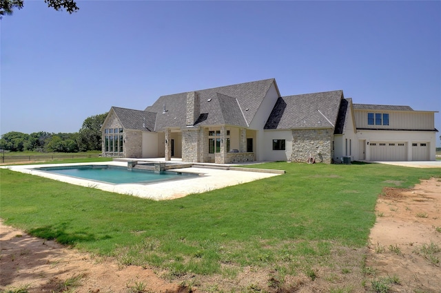 back of house featuring a garage and a lawn