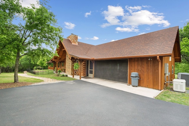 log home featuring central AC unit and a front lawn