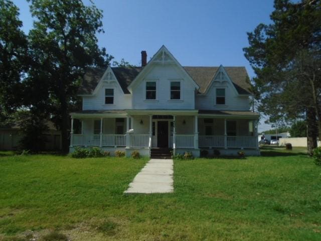 view of front facade with covered porch and a front lawn