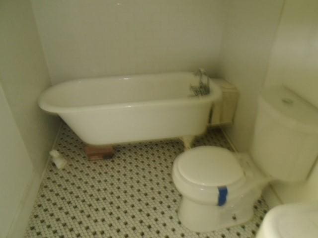 bathroom featuring tile patterned floors, toilet, and a bathing tub