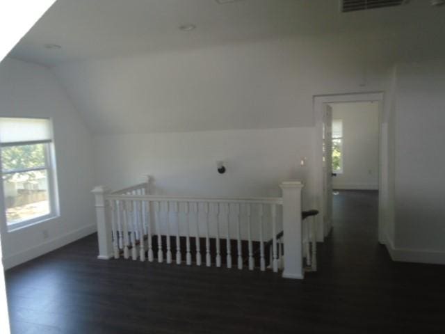 bonus room featuring vaulted ceiling and dark hardwood / wood-style flooring