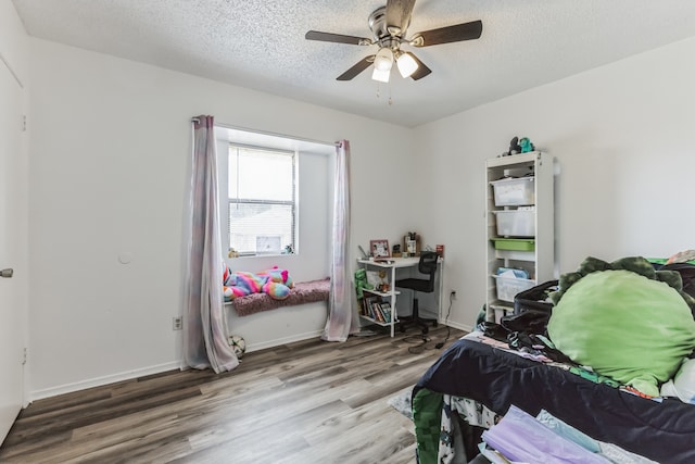 bedroom with a textured ceiling, wood-type flooring, and ceiling fan