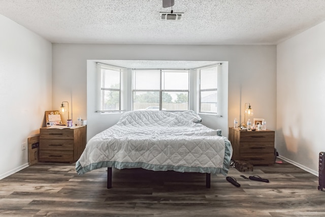 bedroom with dark wood-type flooring and a textured ceiling