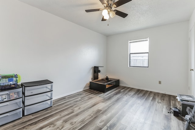 miscellaneous room featuring a textured ceiling, ceiling fan, and wood-type flooring