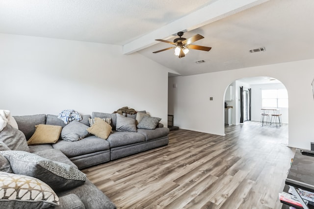 living room featuring lofted ceiling with beams, ceiling fan, and light hardwood / wood-style floors