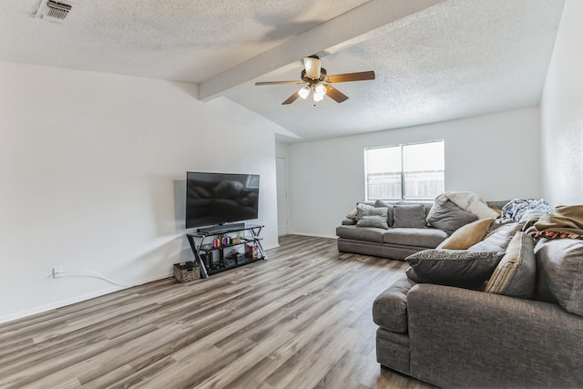 living room featuring lofted ceiling with beams, a textured ceiling, ceiling fan, and wood-type flooring