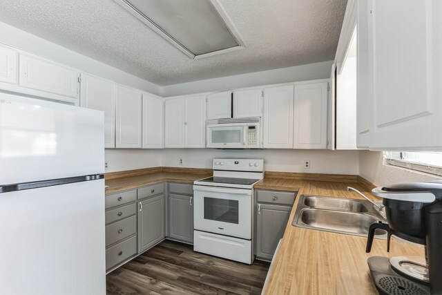 kitchen featuring white cabinetry, white appliances, dark wood-type flooring, butcher block countertops, and sink