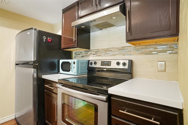 kitchen featuring dark brown cabinetry, decorative backsplash, and stainless steel appliances