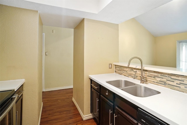 kitchen with dishwasher, sink, backsplash, dark brown cabinetry, and dark wood-type flooring