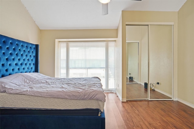 bedroom featuring wood-type flooring, ceiling fan, and a closet