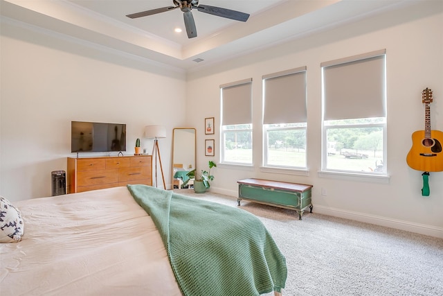 bedroom with ceiling fan, a raised ceiling, carpet floors, and crown molding