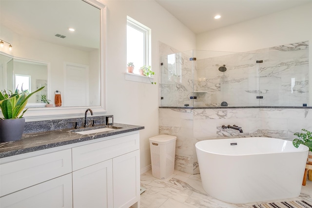 bathroom with independent shower and bath, vanity, and tile walls