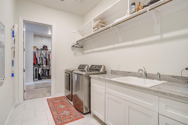 washroom featuring cabinets, independent washer and dryer, and sink