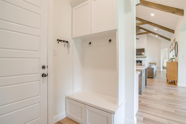 mudroom with vaulted ceiling with beams and light hardwood / wood-style floors