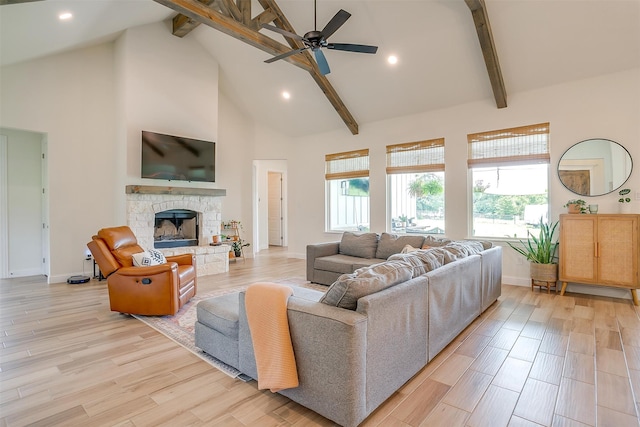 living room with high vaulted ceiling, light wood-type flooring, beamed ceiling, and a stone fireplace