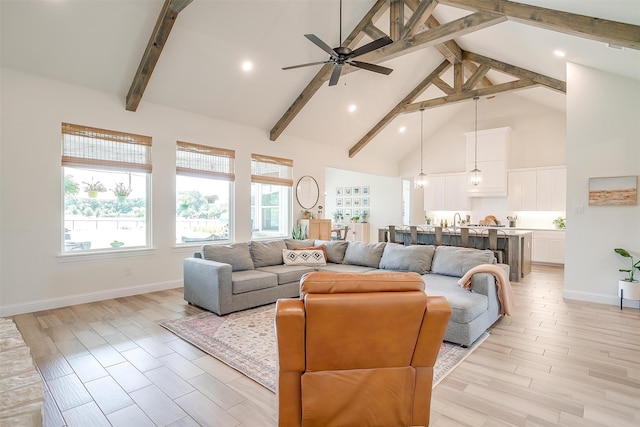 living room featuring ceiling fan, beam ceiling, light hardwood / wood-style floors, and high vaulted ceiling