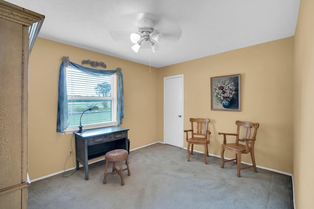 living area featuring light carpet and ceiling fan